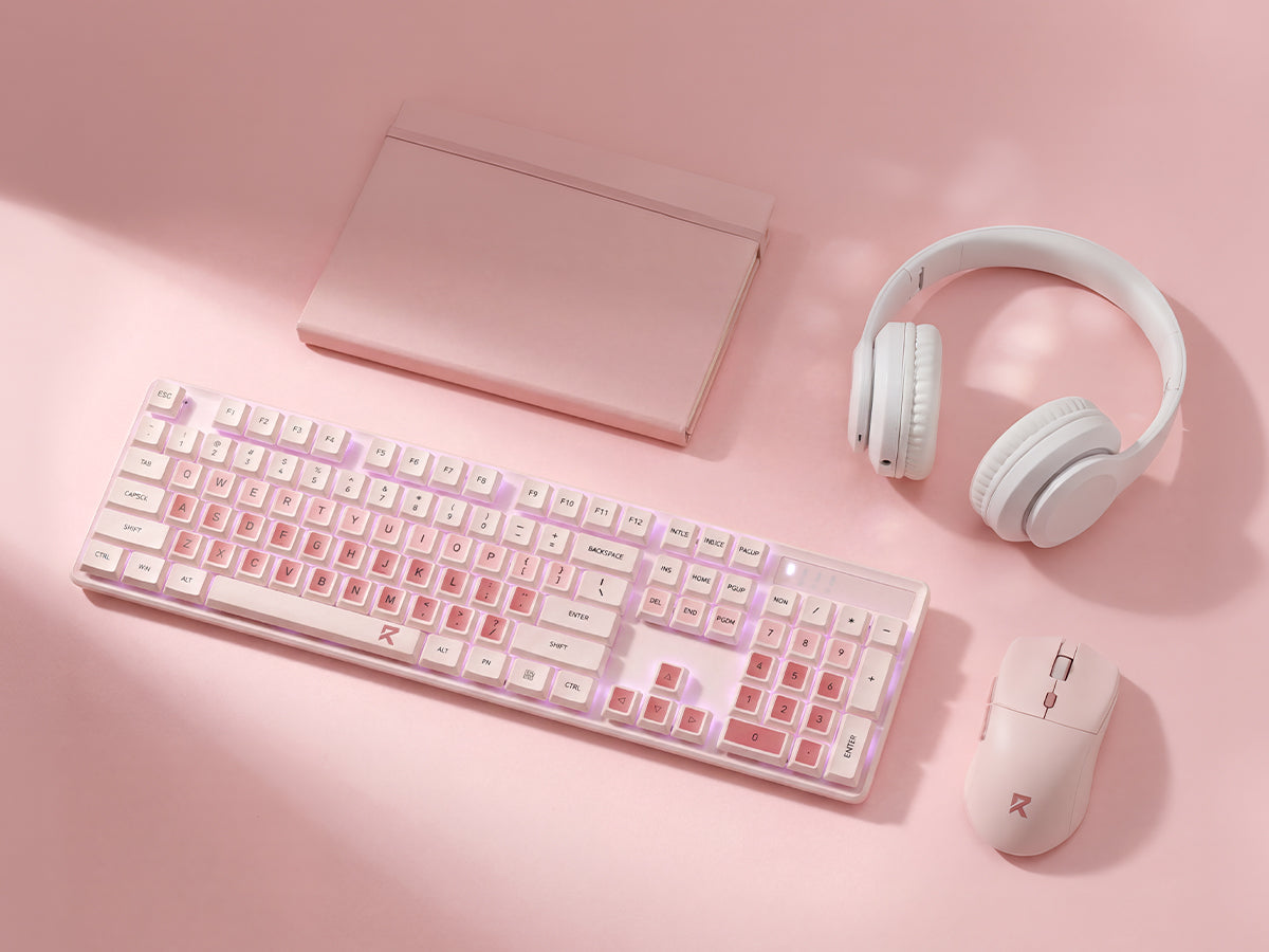 A pink and white tech setup set including a wireless keyboard, mouse, over-ear headphones, and a ...