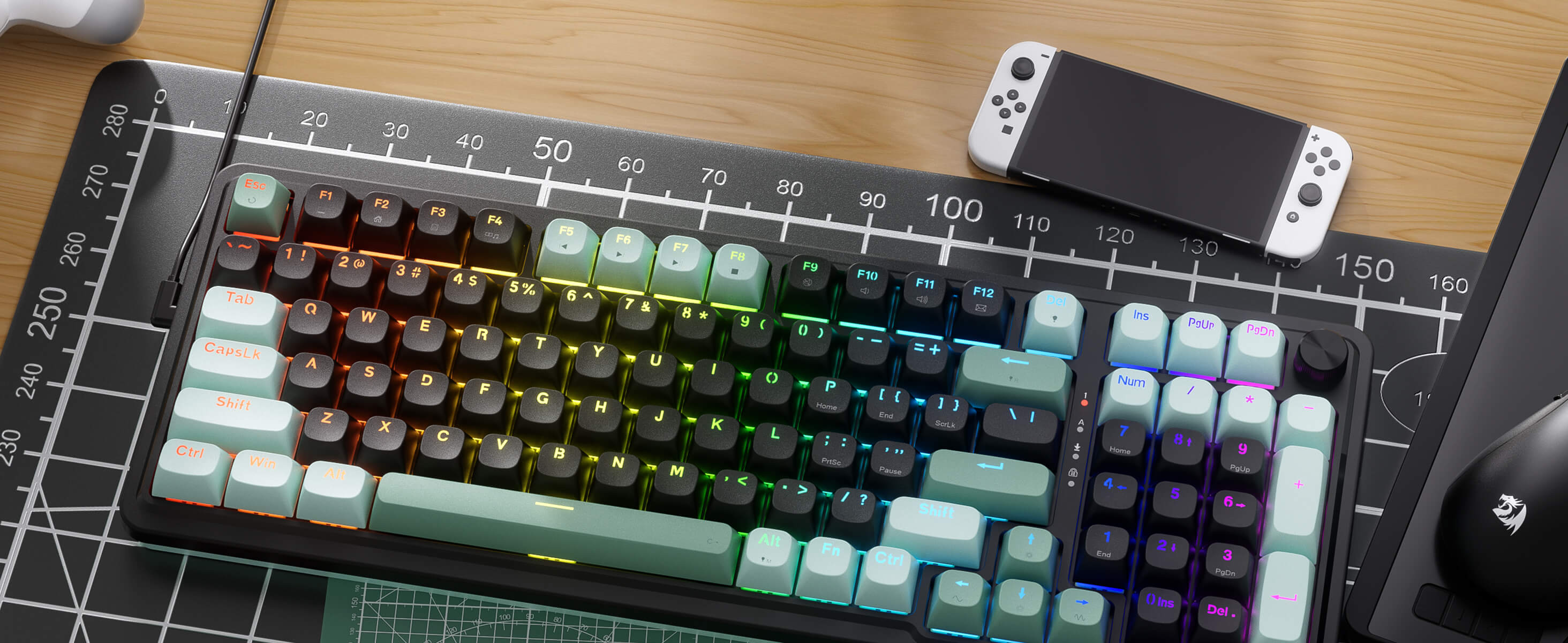 Redragon Mechanical keyboard with RGB lighting on a desk with a smartphone and mouse.