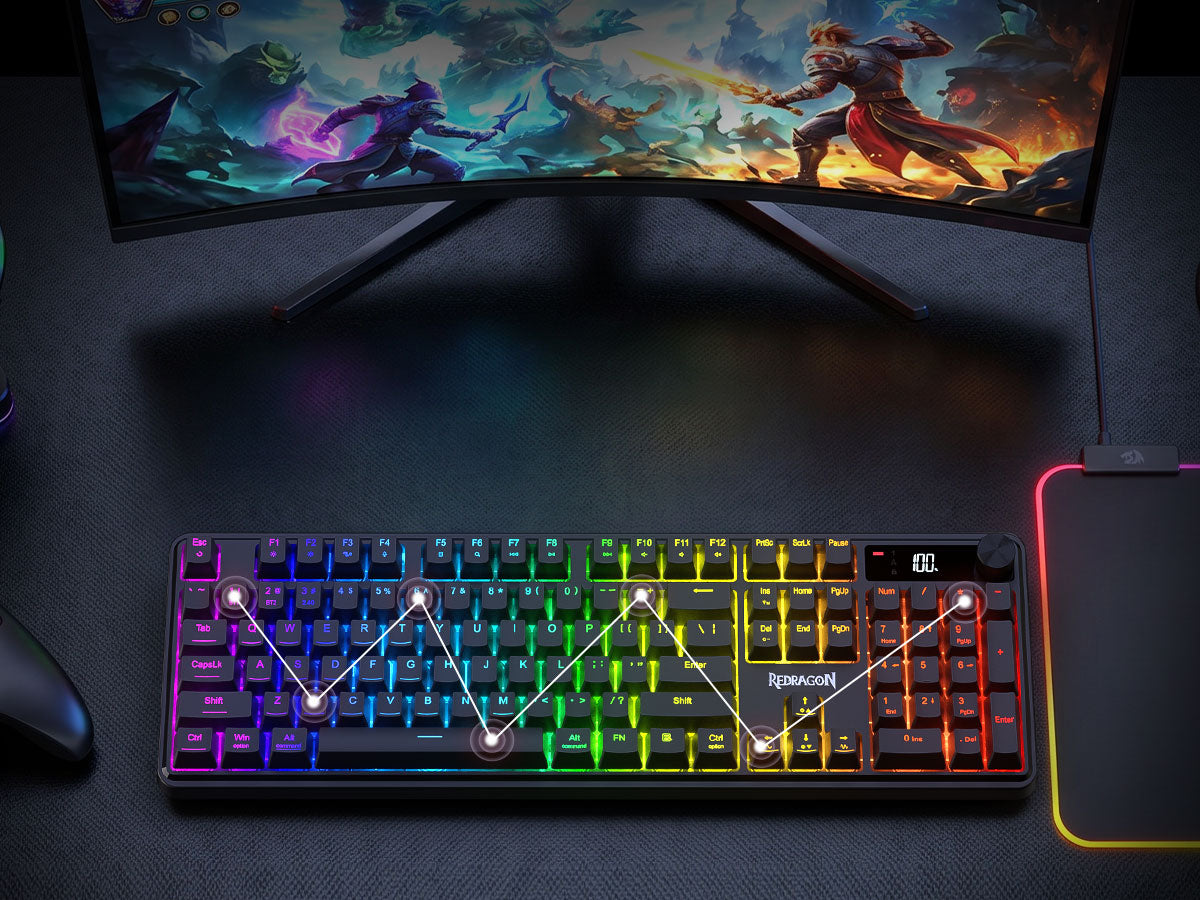 A compact mechanical gaming keyboard with vibrant RGB rainbow backlighting, shown on a dark desk ...